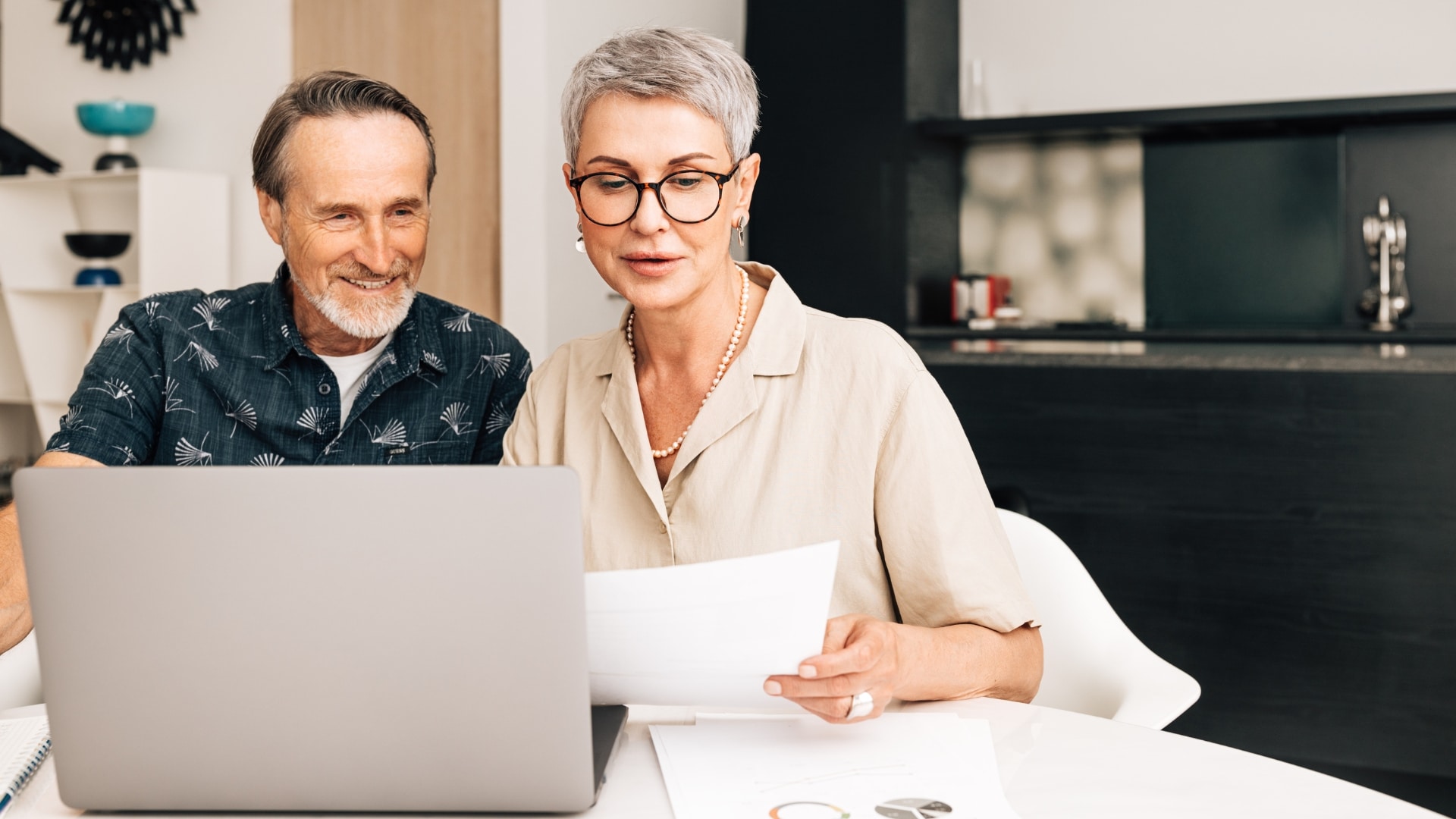 Best Ager Pärchen am Tisch vor dem Laptop